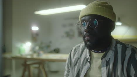 man in yellow beanie and glasses indoors