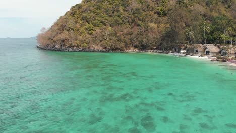 beautiful transparent emerald shallow shore on coral island , thailand - aerial low angle panoramic shot