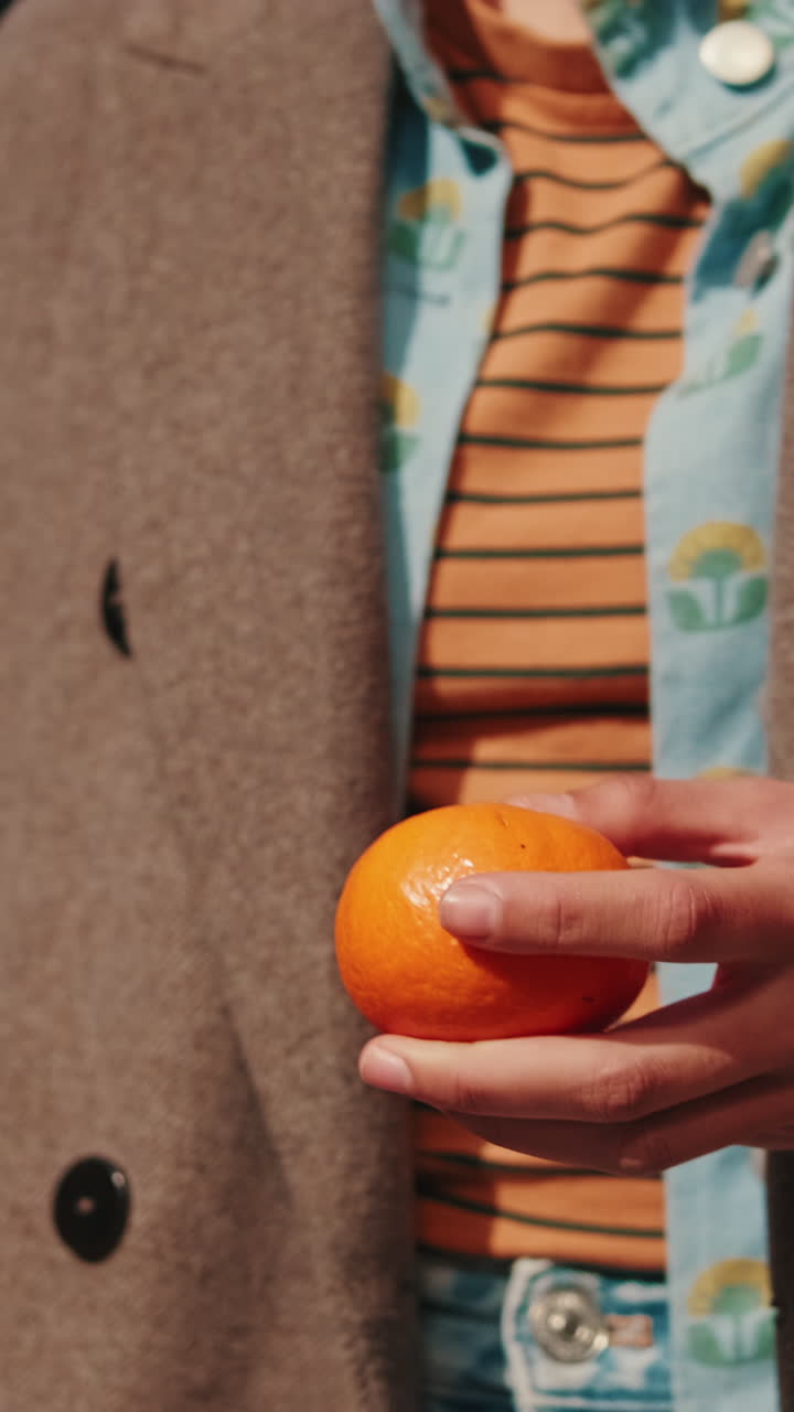 Woman Peeling a Tangerine Outdoors