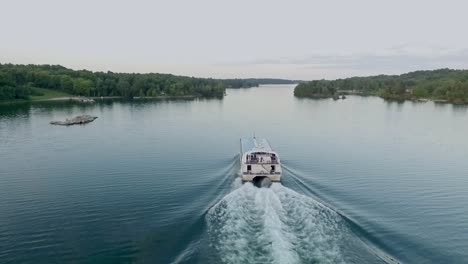 glass topped boat cruises on a river with people onboard holding a canadian flag