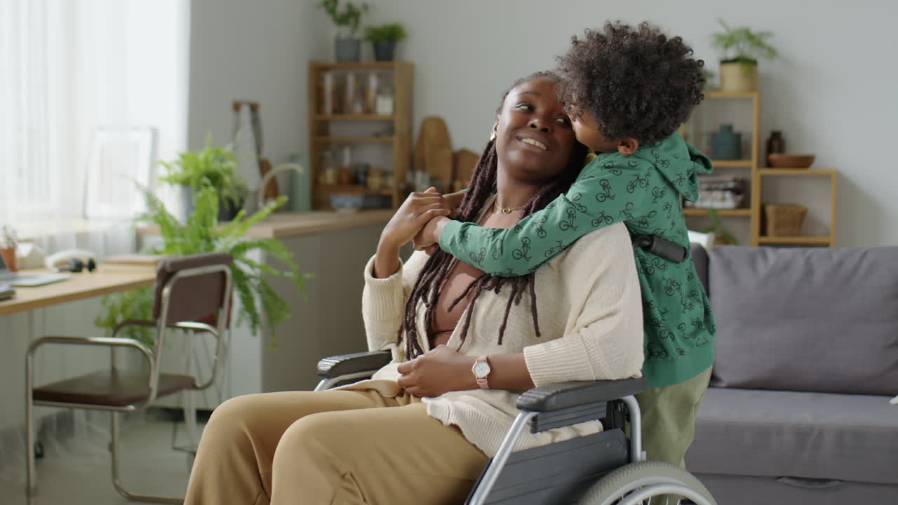 Boy Hugging Mother in Wheelchair at Home