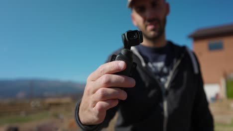 hombre independiente sosteniendo una cámara portátil estabilizada de 3 ejes 4k y moviéndose con la mano