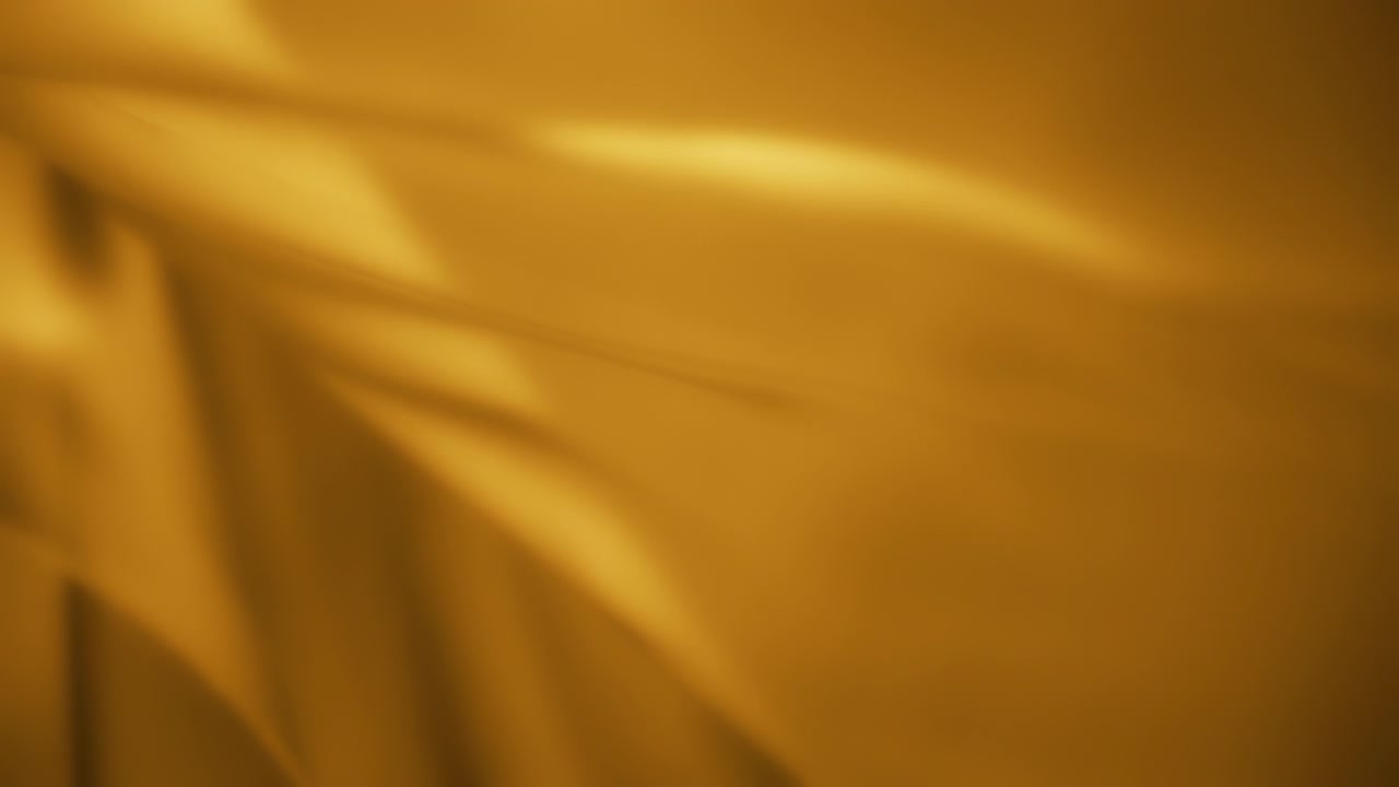 Yellow chiffon wavy fabric flowing in the wind. Slow motion