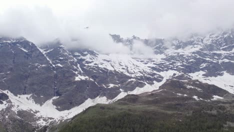 Cloud-snow-covered-mountain-peaks-Italian-alps-rugged-natural-landscape-DRONE