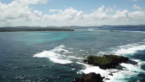 bird's eye shot of rock island with surfers and boats captured, siargao island