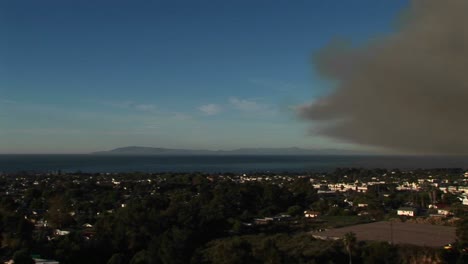 toma panorámica derecha de una comunidad de california cubierta por una nube de humo oscuro de incendios forestales