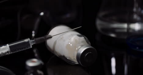 Laboratory-Equipement:-Syringe-And-Medicine-Test-Tubes-And-Flasks-Rotating-On-Black-Background-3