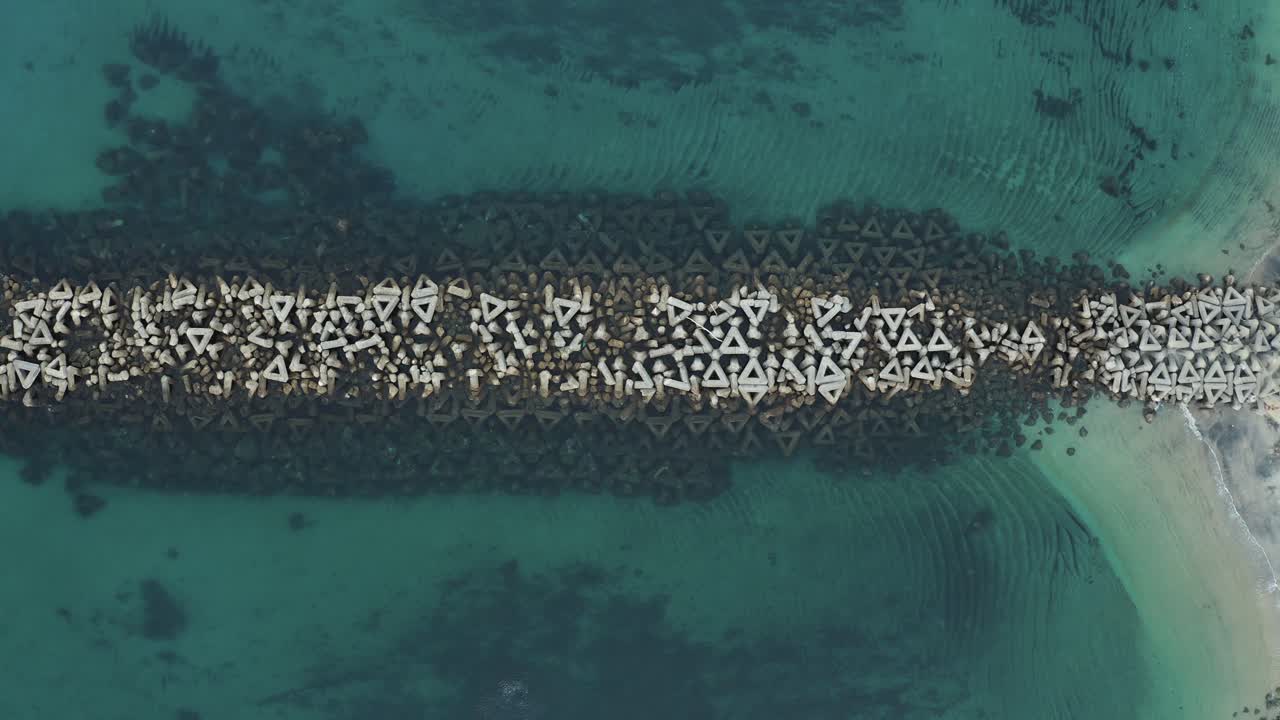해변과 파도가 위에서 아래로 정적 샷을 끊습니다.