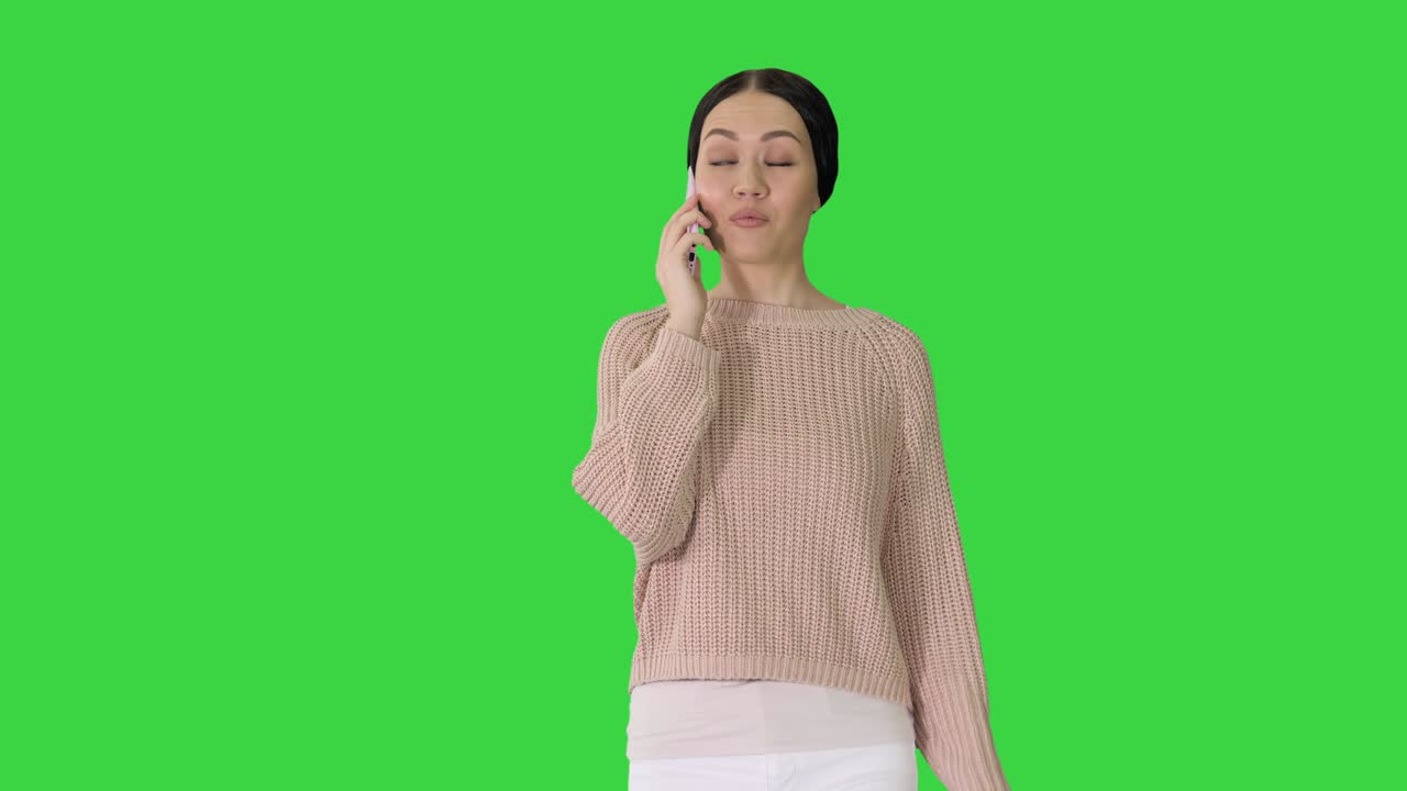 녹색 스크린, 크로마 키를 는 동안 전화로 웃는 젊은 여성