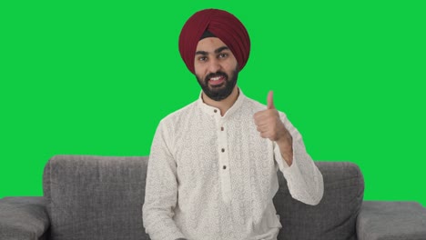 hombre indio sikh feliz mostrando los pulgares hacia arriba pantalla verde