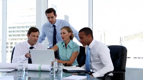 Business-people-using-a-laptop-during-meeting