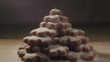 a-large-stack-of-cookies-with-flour-blown-away-on-a-wooden-table,-close-up-static