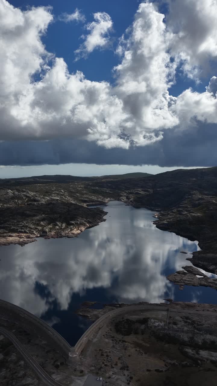 Vertical video of a water reservoir with clouds reflections