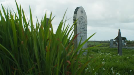 Gravestone-with-grass-in-windy-conditions-slowmotion