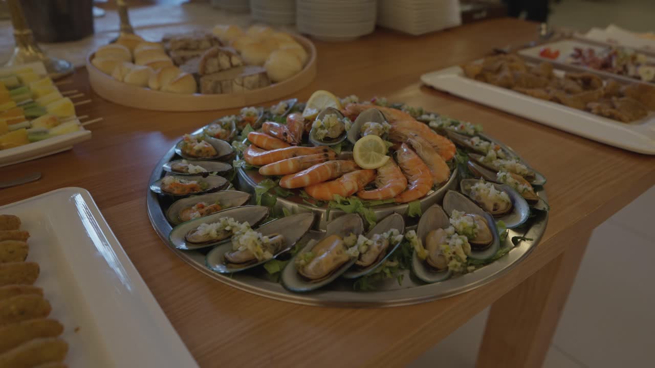 Piatto di frutti di mare freschi con gamberi, cozze, vongole e limone servito su tavolo da pranzo