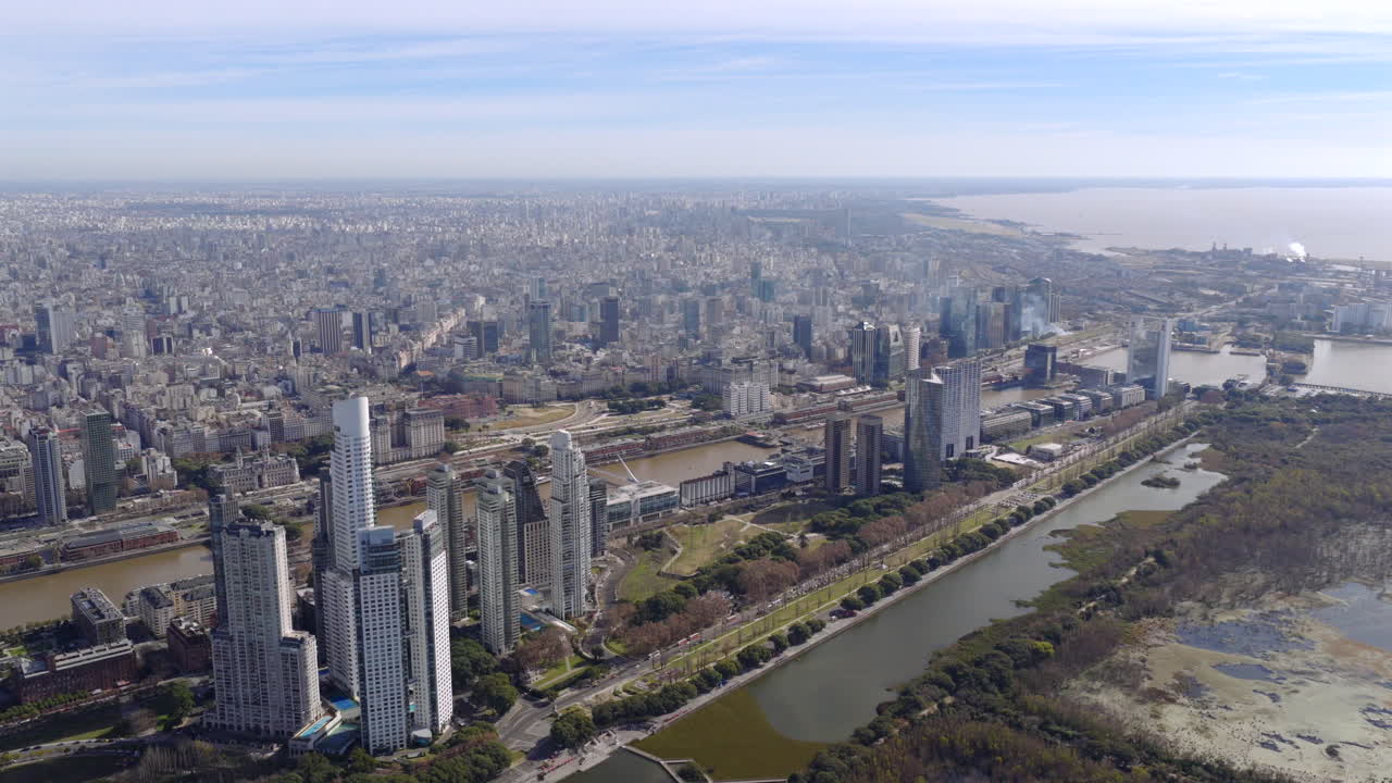 Panoramic aerial drone view of Puerto Madero and downtown Buenos Aires with modern skyscrapers and river in the background