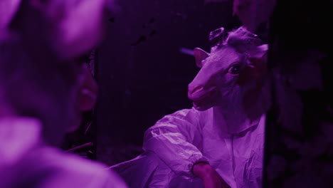 person in a goat mask, purple light