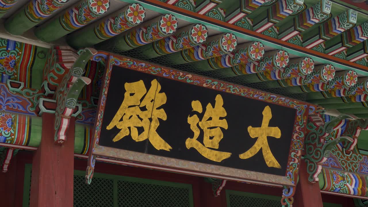 Phong cảnh chuyển động chậm của văn bản viết trên bảng hiệu lối vào mái nhà tại cấu trúc đền điện Đại Điện (Daejojeon) trong Cung điện Changdeokgung ở thành phố Seoul, Hàn Quốc, một di sản kiến trúc lịch sử của châu Á.