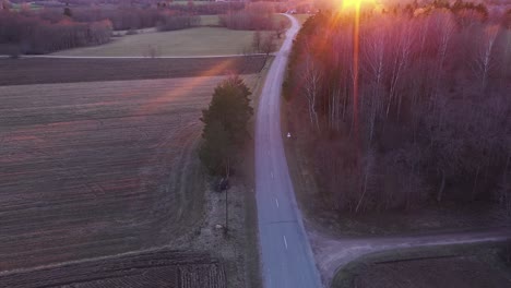 vista aérea de una carretera rural vacía con campos a la hora dorada