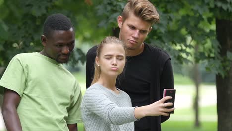 teenagers taking a selfie in a park