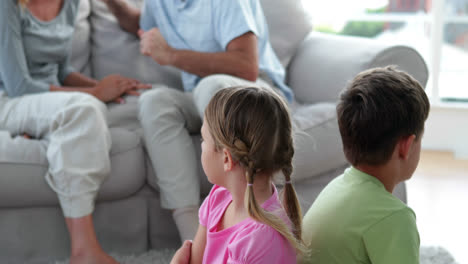 niños pequeños escuchando a sus padres peleando en el sofá