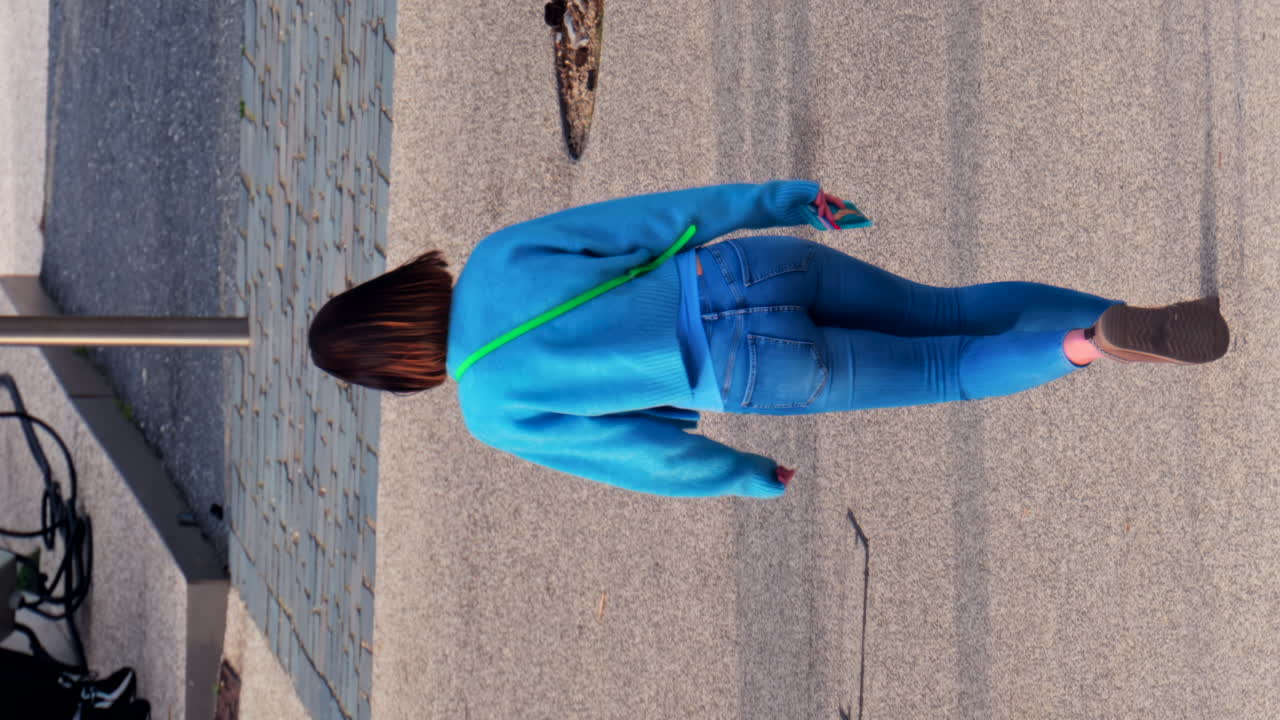 Woman walking on the streets of the city in daylight. Vertical