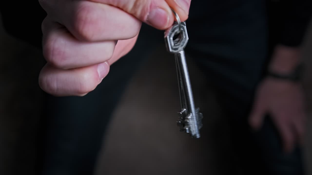 мужская рука показывает домашние ключи в камеру, крупный план