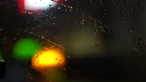 Limpiaparabrisas-En-El-Coche-Limpiando-Las-Gotas-De-Lluvia-A-Cámara-Lenta-De-Cerca-Por-La-Noche