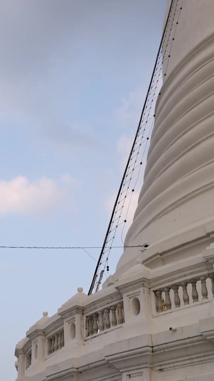 Uma vista serena do pagode branco de Wat Prayurawongsawat em Banguecoque, exibindo arquitetura intrincada sob um céu límpido.