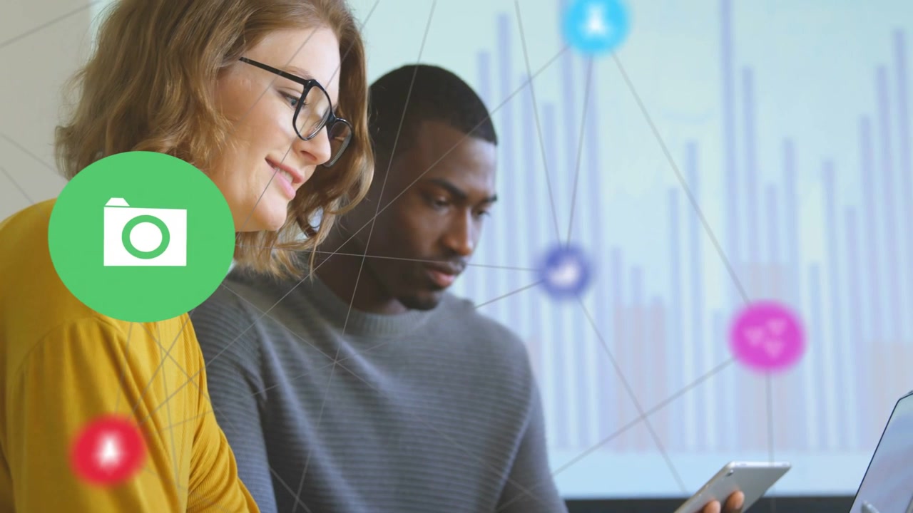 Woman typing and man tapping device taps activating icons showing business network over chart