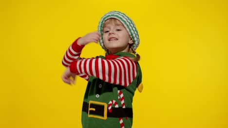 Kid-girl-in-Christmas-elf-Santa-helper-costume-dancing,-fooling-around.-New-Year-holiday-celebration