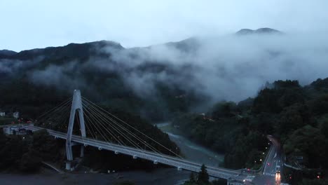 alto dron aéreo sobre el espeluznante valle de niebla al atardecer con pocos autos conduciendo