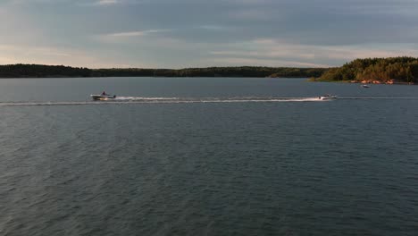 high speed boat chase from perpendicular angle - contrast between the archipelago, sea and the two motorboats