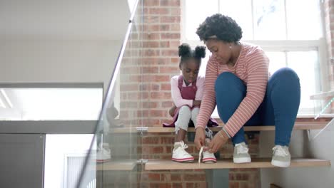 Afroamerikanische-Mutter-Berät-Und-Bindet-Ihrer-Tochter-Zu-Hause-Schuhe,-Zeitlupe