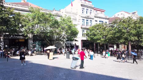 bustling square in front of livraria lello bookstore with people walking under bright daylight