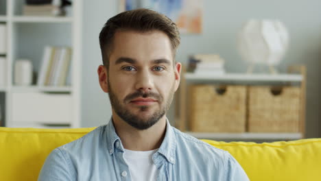 close up of the attractive man looking to the camera and smiling in the living room