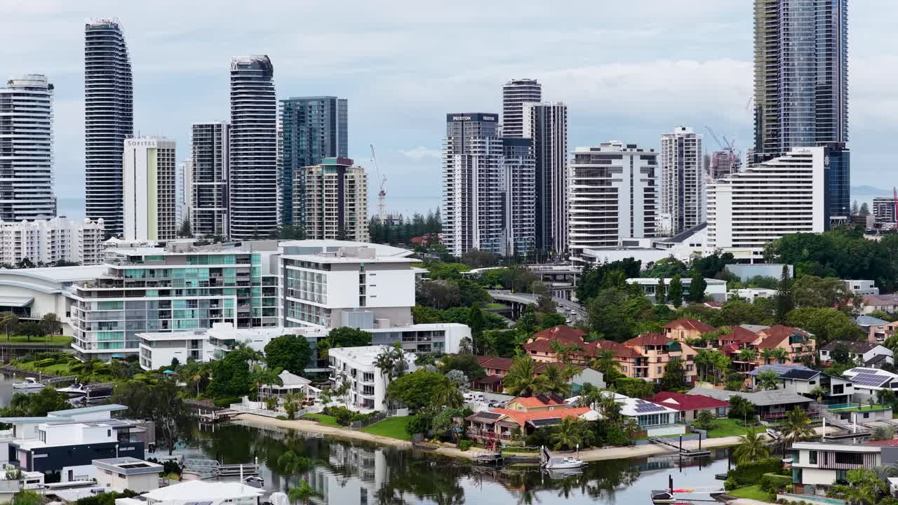 Aerial footage of Gold Coast's skyline with modern buildings and waterways under clear daylight