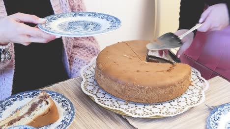 cortando un pastel casero y colocando una pieza en un plato de porcelana tradicional alemania