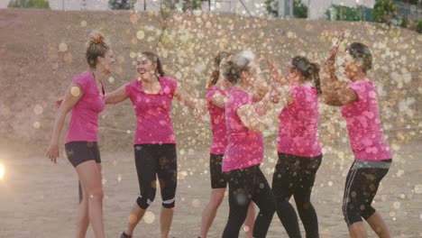 animation of light spots over diverse women at obstacle course high fiving