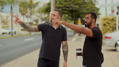 two men having a conversation and pointing on a city sidewalk