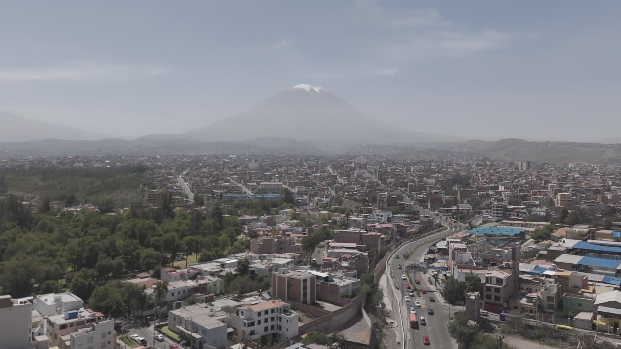 Sideways drone shot above Arequipa Peru on a bright day with some mist with view on the mountain LOG