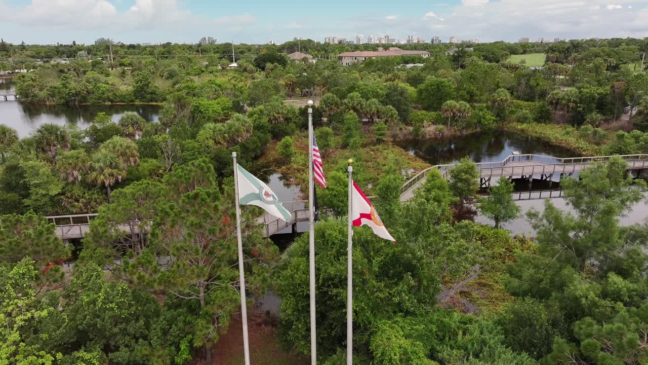 imagen de avión no tripulado de las banderas de estados unidos, florida y nápoles frente al lujoso club de campo.