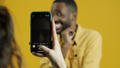 smiling man being photographed by woman