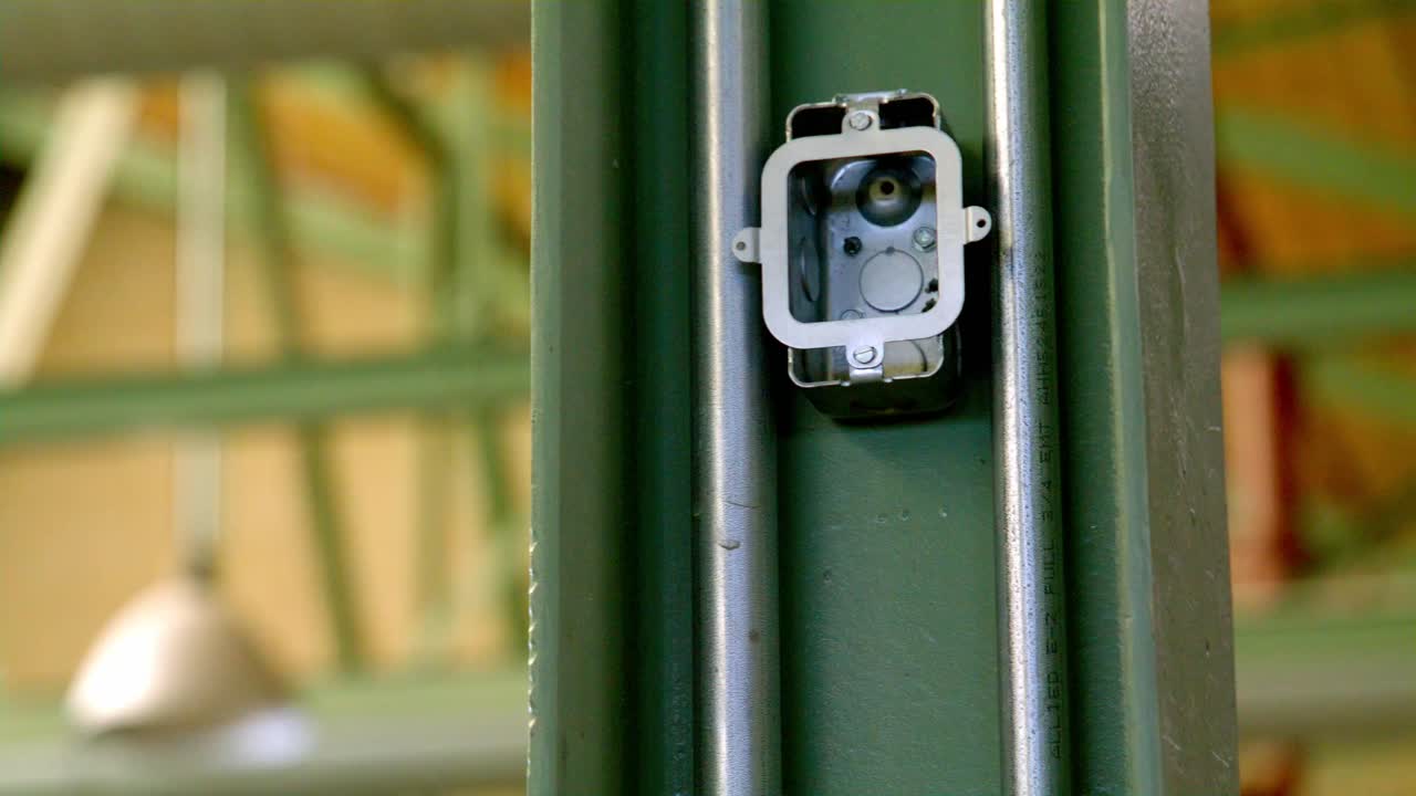Unfinished industrial electric outlet on a steel beam with video panning left to right.