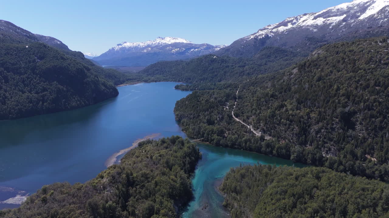 Downward aerial movement of a serene mountain lake surrounded by forest at Parque Nacional Los Alerces, Patagonia, Argentina.