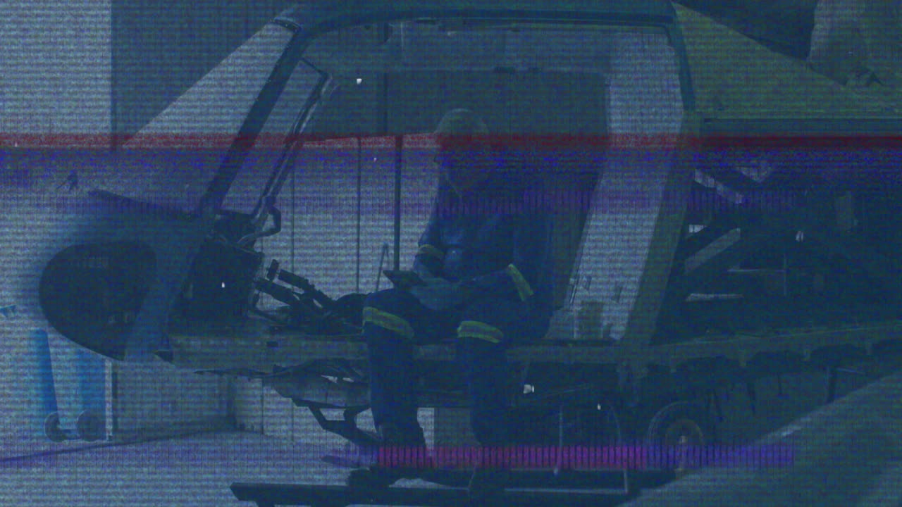 In helicopter cockpit, person in blue uniform experiencing animation static interference