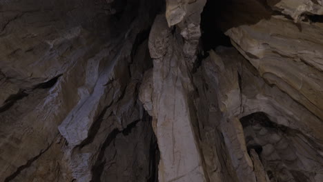 a vast cave interior featuring stalagmites and stalactites, lit dramatically