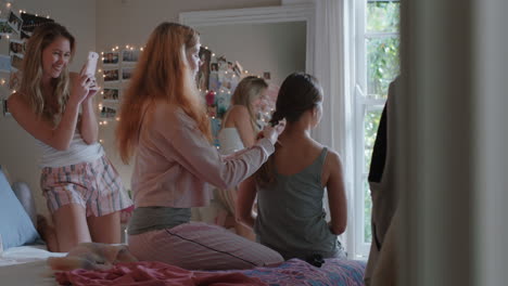 happy girl friends hanging out together at home tying hair making braids enjoying friendship having fun posing for photo relaxing in bedroom on weekend