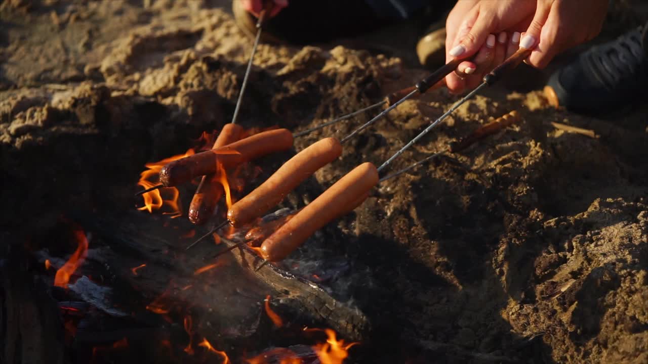 Hot dog in cottura su un falò in spiaggia