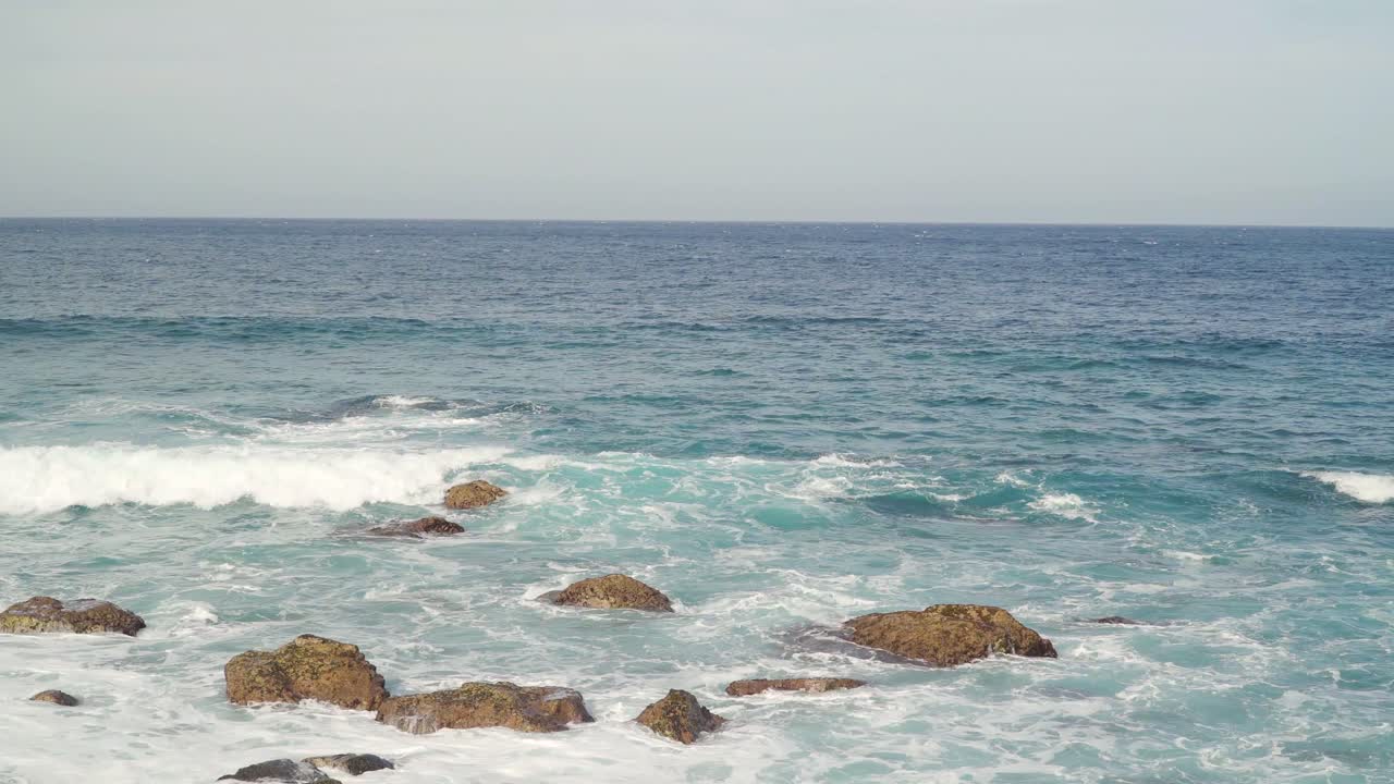 Atlantic Ocean waves crushing into the stone beaches of madeira island, Portugal.